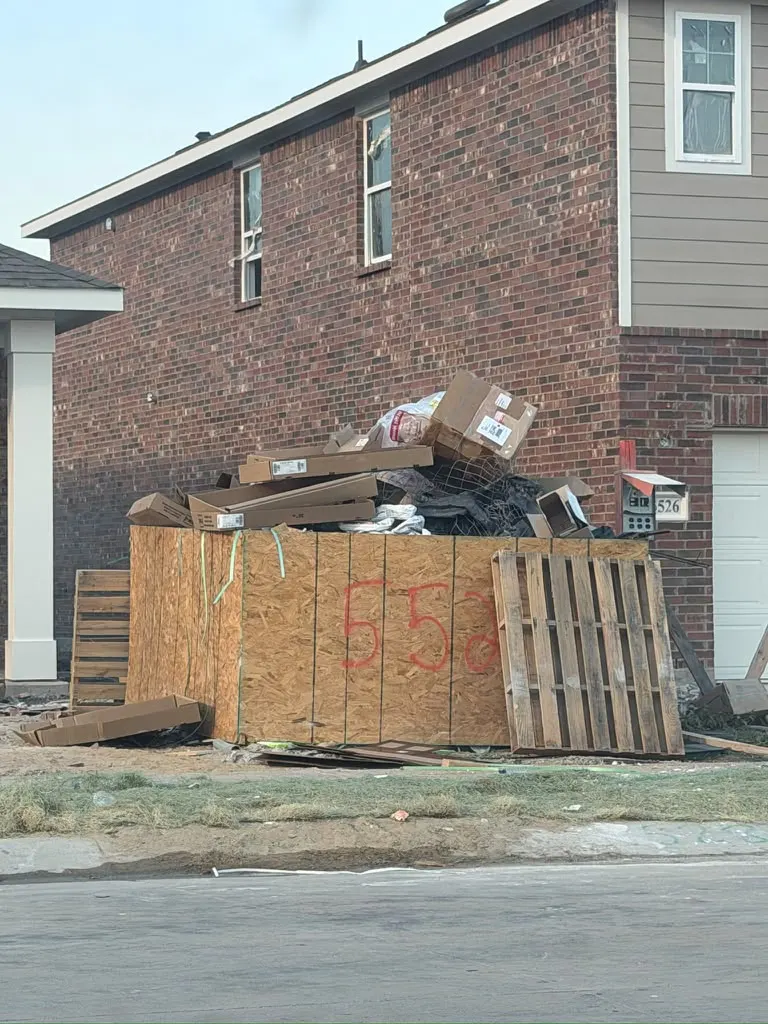 Construction debris, boxes and pallets piled at a new-build home site