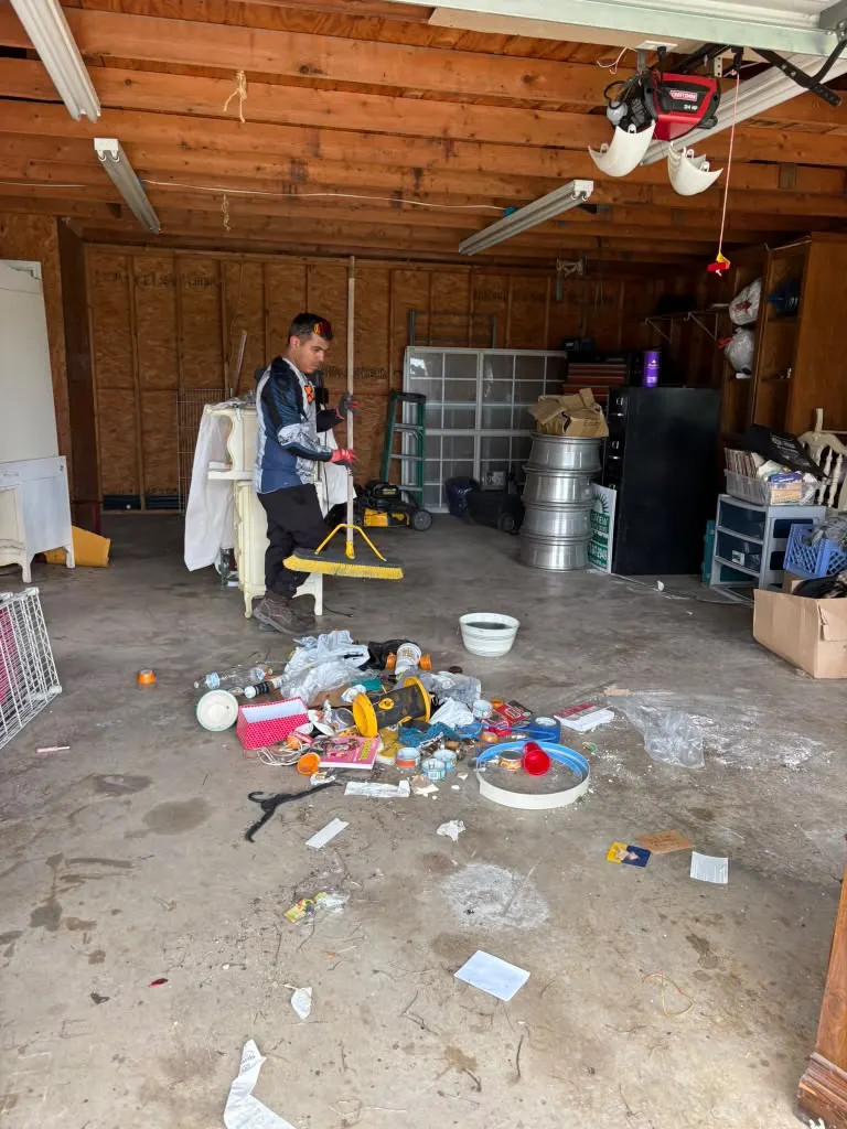 Crew member clearing out a cluttered garage